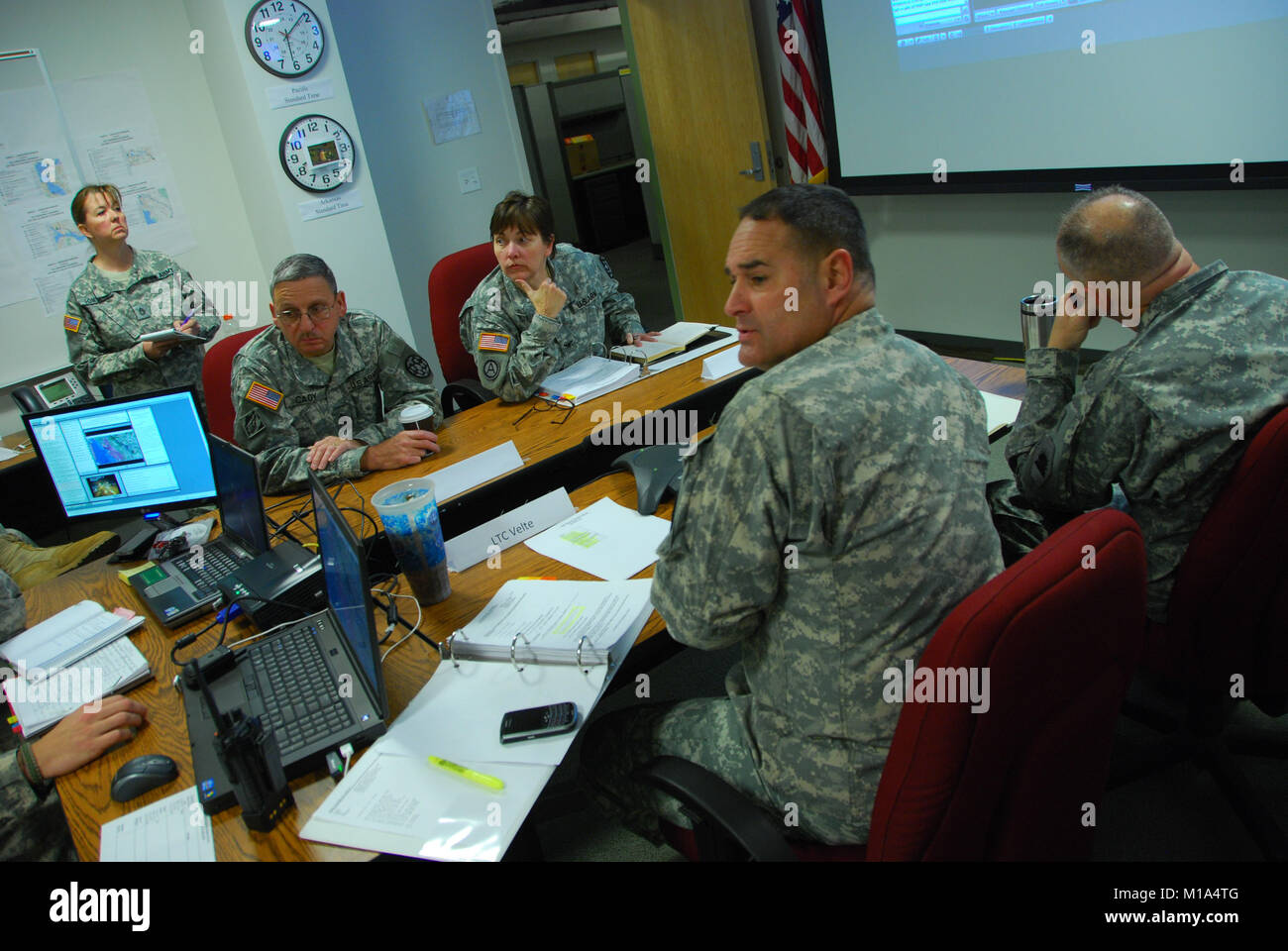 California Army National Guard leaders from the 115th Regional Support Group, seated from left to right, Command Sgt. Maj. Randall Cady, Col. Rene Horton, commander, Lt. Col. Kurt Velte, executive officer, and Col. Keith Tresh, incoming commander, sit in the Emergency Operations Center in Roseville and get the latest updates coming in from the field at 2:30 a.m., Jan. 6, 2012, during the 115th Regional Support Group's Emergency Deployment Readiness Exercise, which had 60 vehicles and 217 troops moving their wheeled assets around the state in response to a earthquake scenario. The troops report Stock Photo