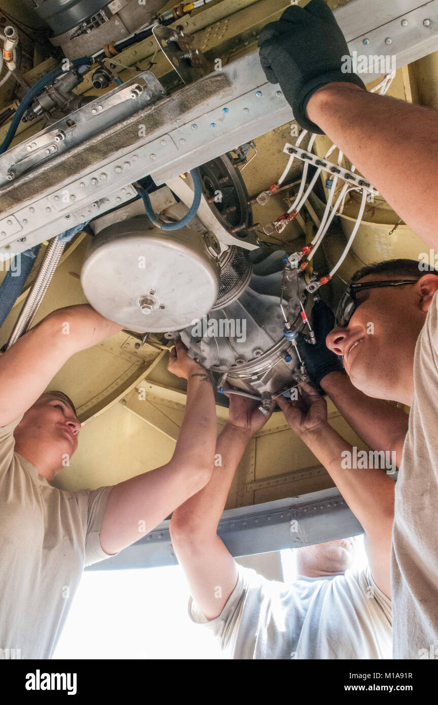 From left to right: Staff sergeant Sarah Schumacher and private first classes Ismael Aguilar and Jose Callazo, California Army National Guard aviation mechanics with Bravo Company, 1-126th Aviation Regiment out of Stockton, field-repair the auxiliary power unit, a smaller jet engine, on a CH-47D Chinook helicopter at the Rocky Fire helibase near Clear Lake, Calif., Aug. 1.   The rare field-repair and replacement of an APU can take anywhere from four to six hours. The engine weighs close to 75 pounds and without having the proper hoist in the field, requires at least three people to lift and ho Stock Photo
