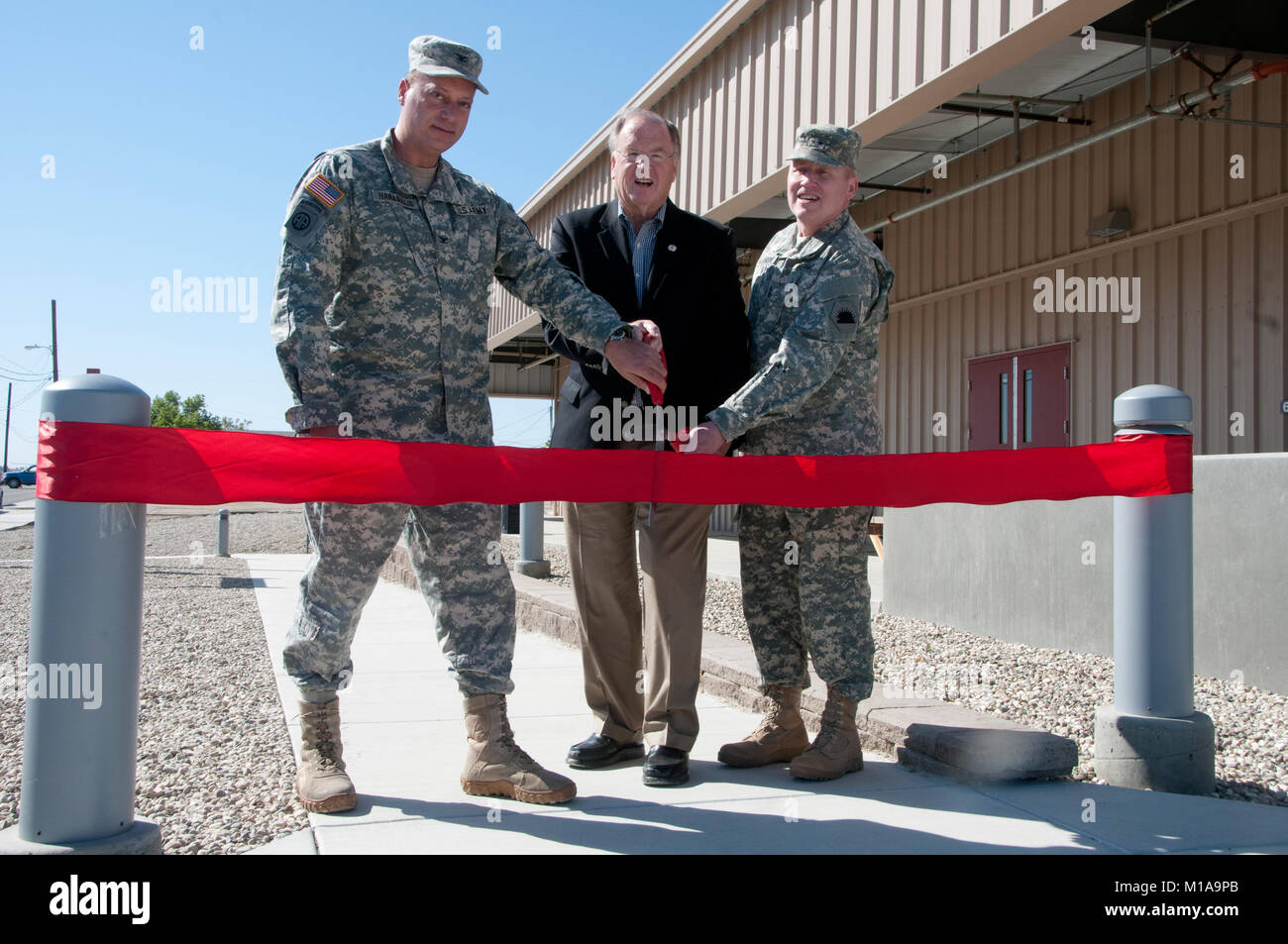 Maj. Gen. Lawrence A. Haskins, Commander California Army National Guard, US Congressman Sam Farr, and Col. John N. Haramalis, Camp Roberts Commander, unveil the new dining facility on Camp Roberts, along with a tour of two other new training facilities, May 13, 2014. The new 8,600 square-foot dining facility will be utilized by thousands of members of the military who train at camp Roberts  annually. (Air National Guard photo by Master Sgt. Julie Avey) Stock Photo