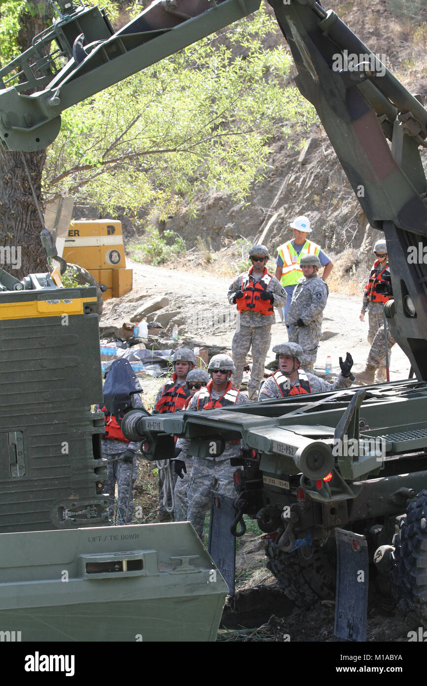 Members of the 132nd Multirole Bridge Company (MRBC), California Army National Guard, watch as a crane positions itself to release a ramp at the Cache Creek River Aug. 7 in Yolo County, California. (U.S. Army National Guard photo/Staff Sgt. Eddie Siguenza) Stock Photo