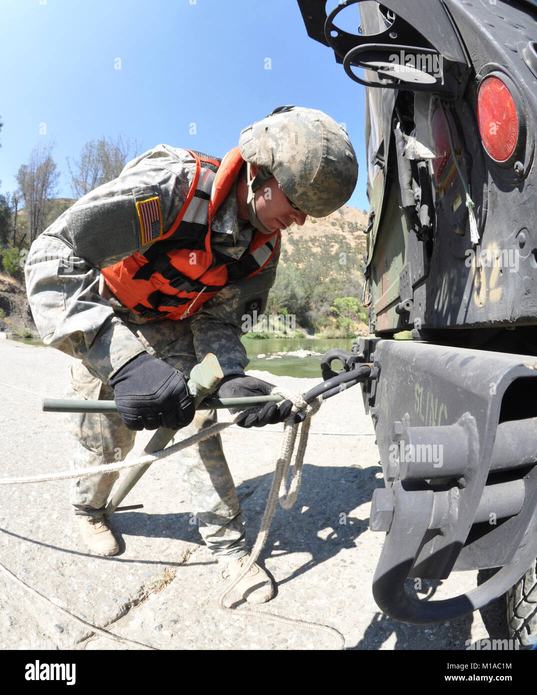 Spc. Jason Lansdale of the 132nd Multirole Bridge Company (MRBC), based in Redding, California, ties a rope to a humvee Aug. 7 at Cache Creek National Park in Yolo County, California. (U.S. Army National Guard photo/Staff Sgt. Eddie Siguenza) Stock Photo