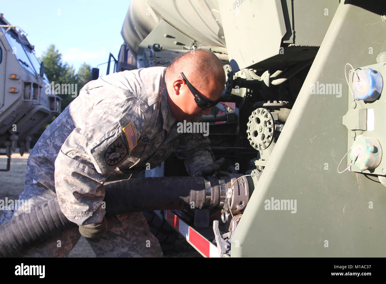 Sgt. Michael Aguilar of the 756th Transportation Company, California Army National Guard, connects a fueling hose Aug. 11 at Eel River Conservation Camp during the Rocky Fire in Northern California. (U.S. Army National Guard photo/Staff Sgt. Eddie Siguenza) Stock Photo