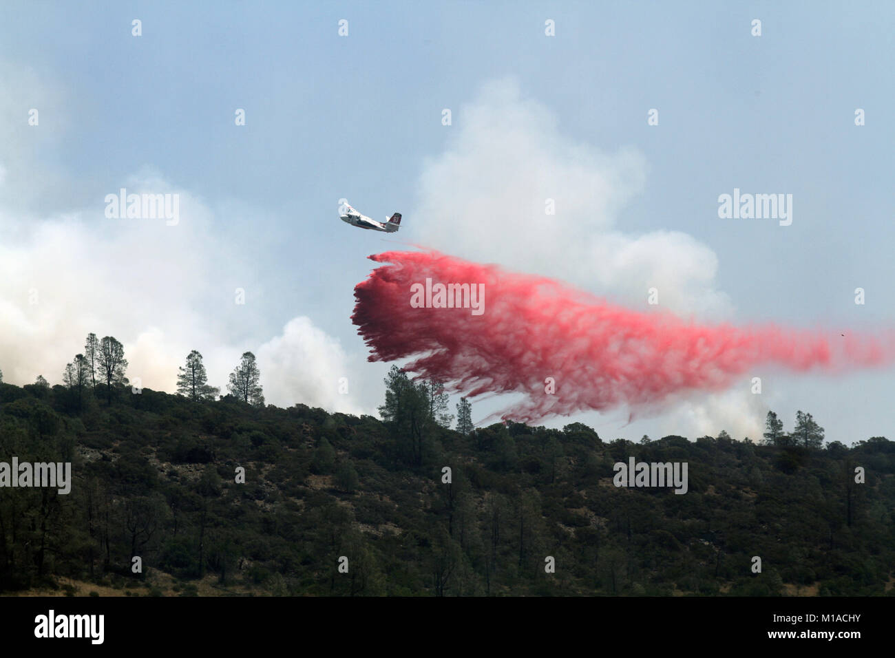 A Department of Forestry and Fire Protection (CAL FIRE) aircraft drop fire retardant Aug. 12 on a hilltop east of Clearlake, California, during the Jerusalem Fire in Lake County, California. (U.S. Army National Guard photo/Staff Sgt. Eddie Siguenza) Stock Photo
