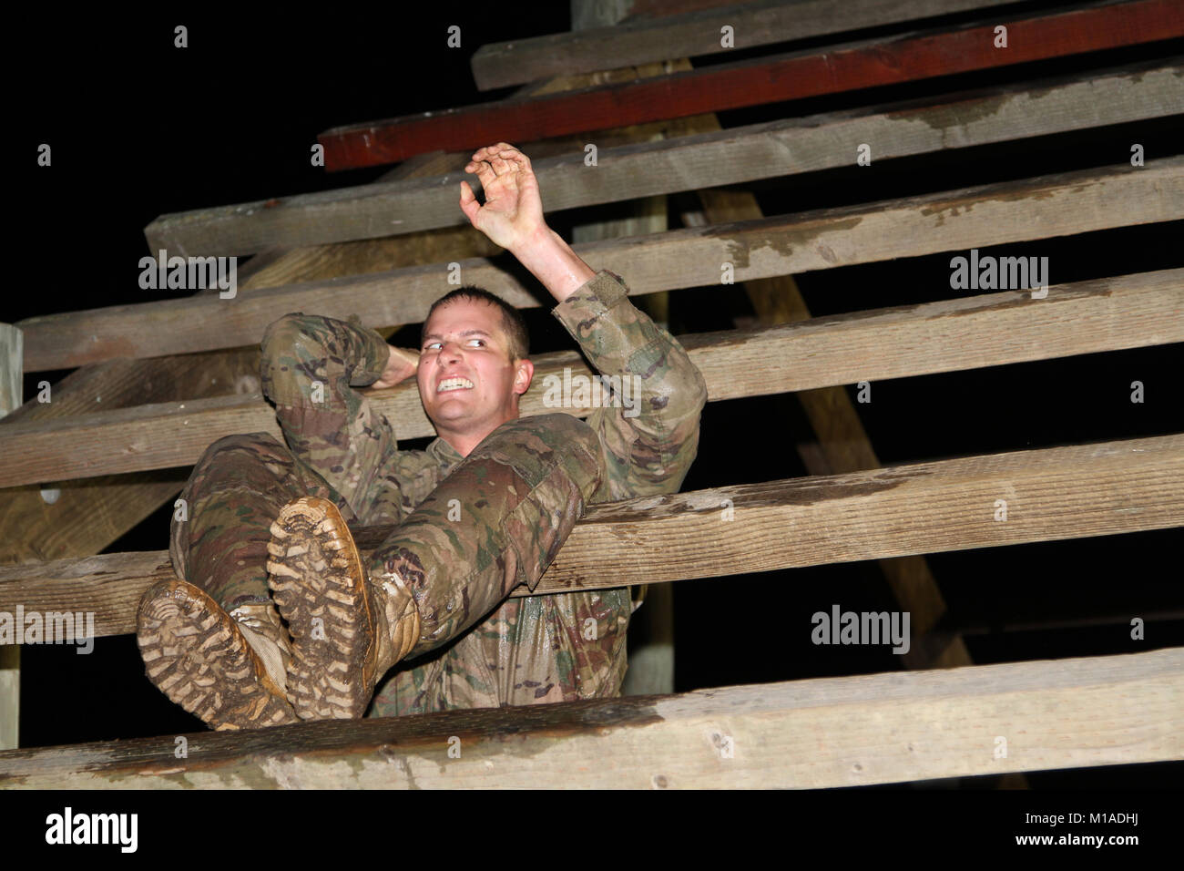 A participant grimaces as he climbs an obstacle during the California Army National Guard’s 2015 Best Warrior Competition Nov. 16-20 at Camp San Luis Obispo, San Luis Obispo, California. (U.S. Army National Guard photo/Staff Sgt. Eddie Siguenza) Stock Photo