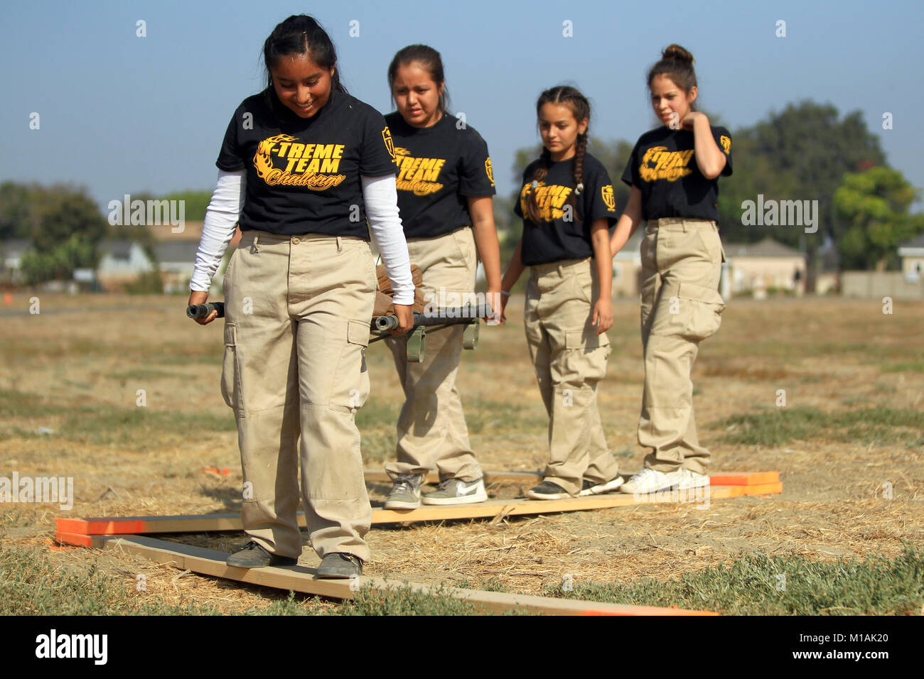 California Cadet Corps Cadet Jocelyn Perez, an eighth grader at Frank L. Walton Middle School in Compton, California, leads her team across a balance beam while carrying a sandbags on a litter Oct. 28, 2017, during the California Cadet Corps Xtreme Team Challenge at Joint Forces Training Base Los Alamitos, California. Cadets persevered through four aspects of the litter carry challenge including the balance beam, ascending and descending a tower, overhead carry, and low-crawl. (Air National Guard photo by Senior Airman Crystal Housman) Stock Photo