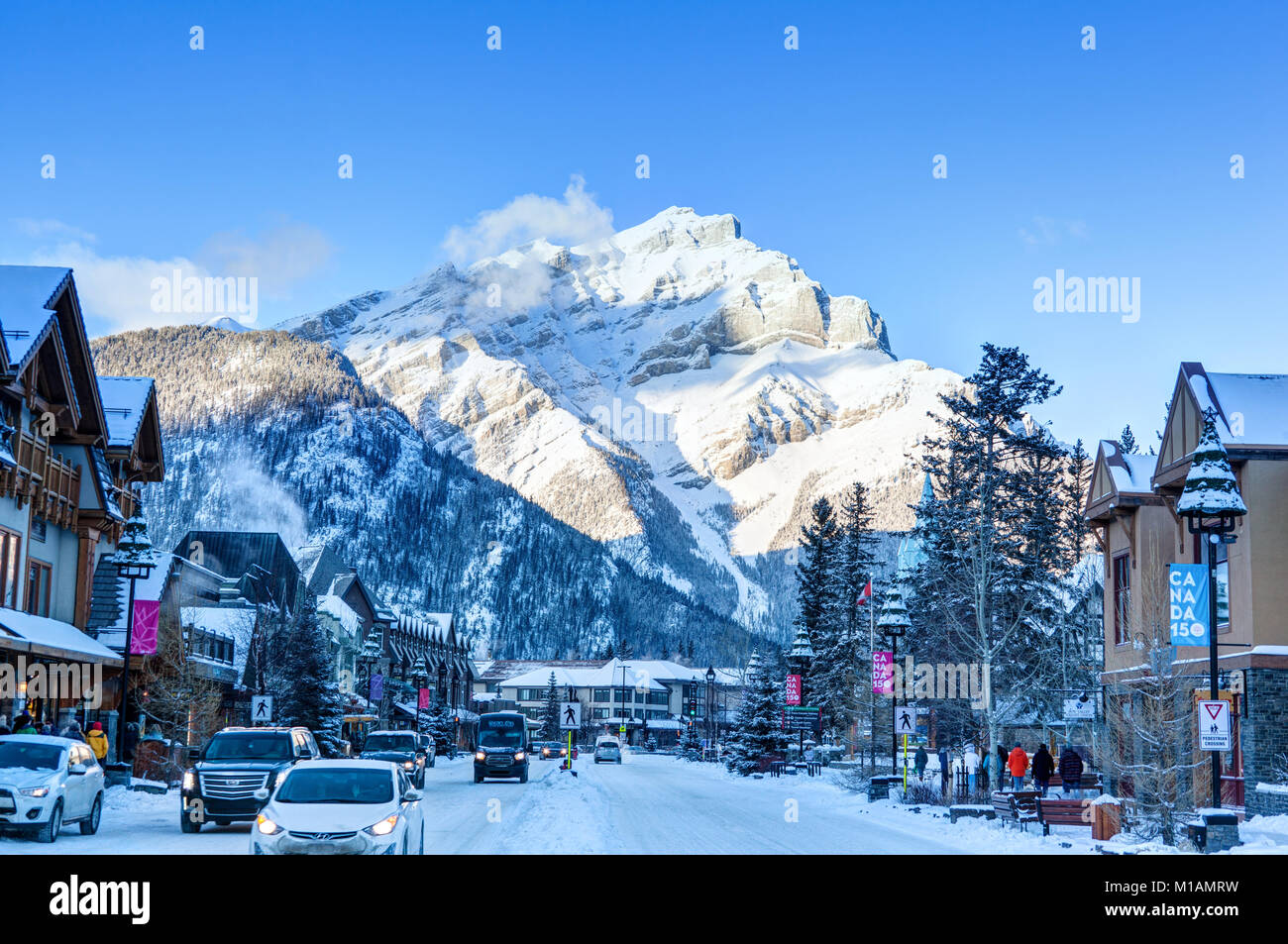 BANFF, CANADA - DEC 22, 2017: Winter scene on Banff Avenue in the Banff National Park with Cascade Mountain in the background. The townsite is a major Stock Photo