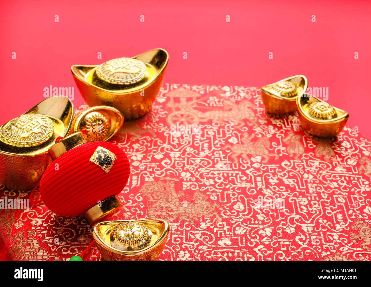 Chinese new year decoration,close up golden ingots ( ang pow )and lamp on red oriental pattern fabric hexagon box with chinese style pattern on red,Ch Stock Photo