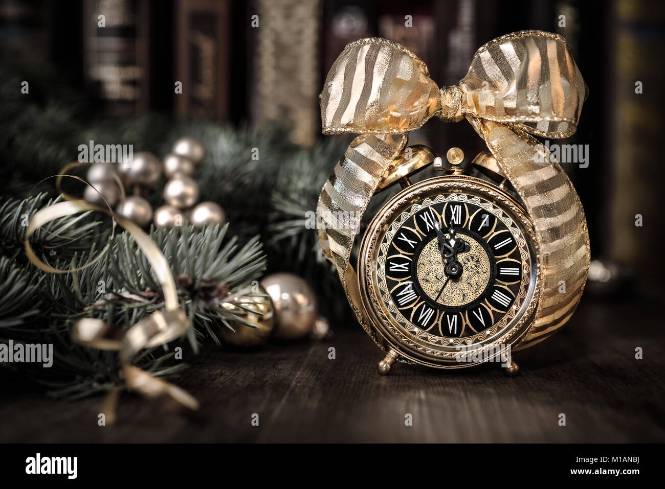 Vintage alarm clock in traditional study room showing five to midnight. Happy New Year! Stock Photo