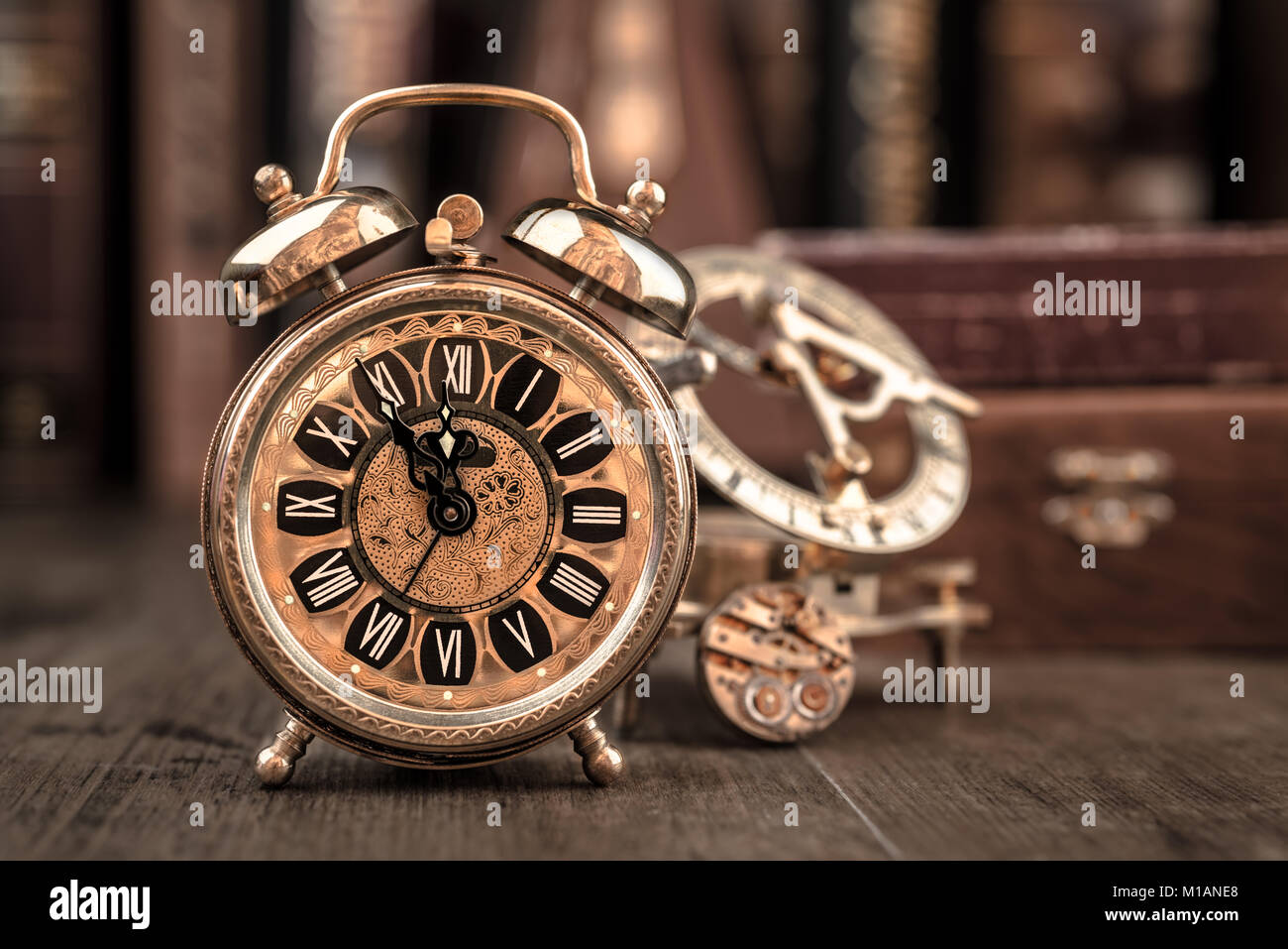 Vintage alarm clock showing five to twelve on the wooden table in study room. Happy New Year 2015! Stock Photo