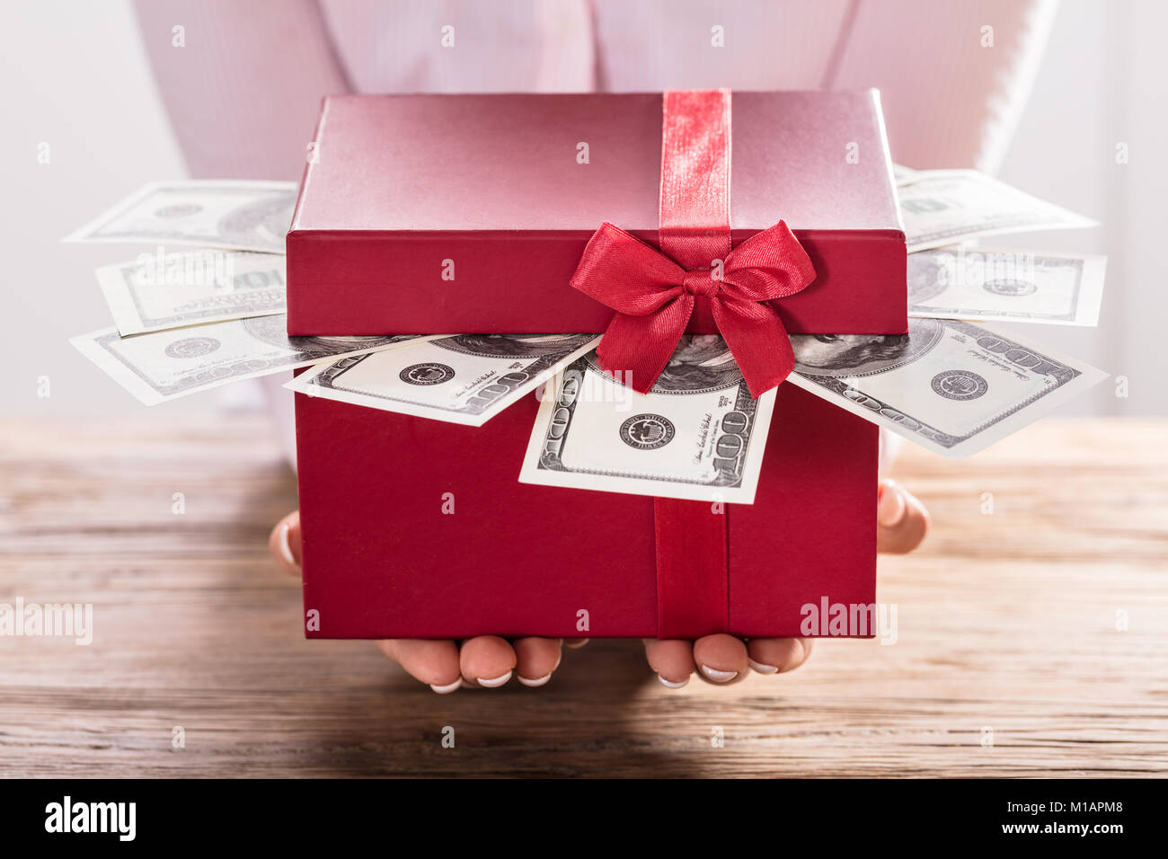 Close-up Of A Woman Holding Gift Box Of Us Dollar Bills Stock Photo