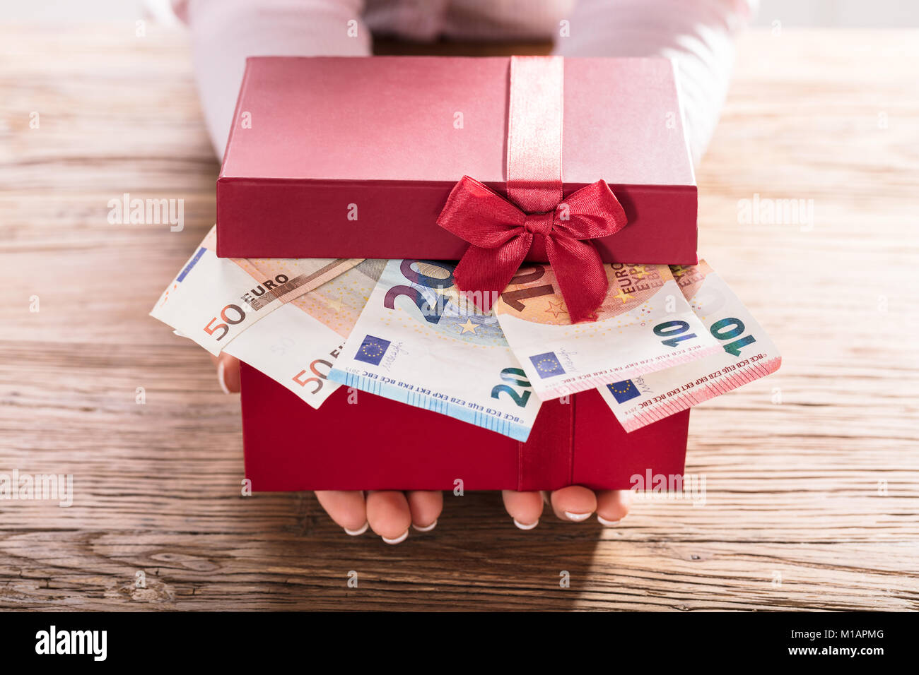 Close-up Of A Woman Holding Gift Box Of Euro Bills Stock Photo