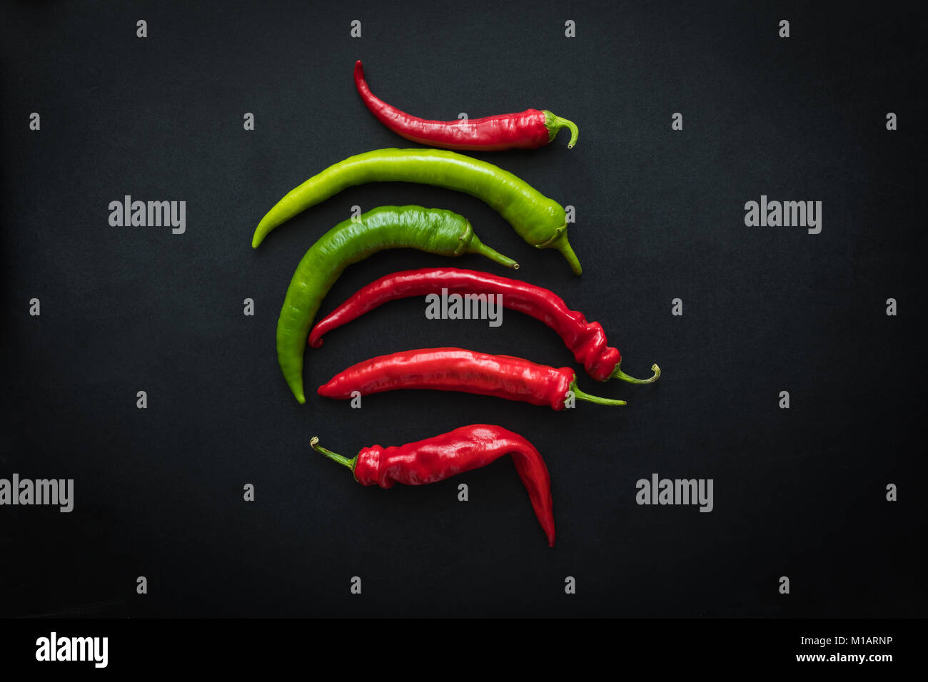 top view of red and green fresh chili peppers isolated on black Stock ...