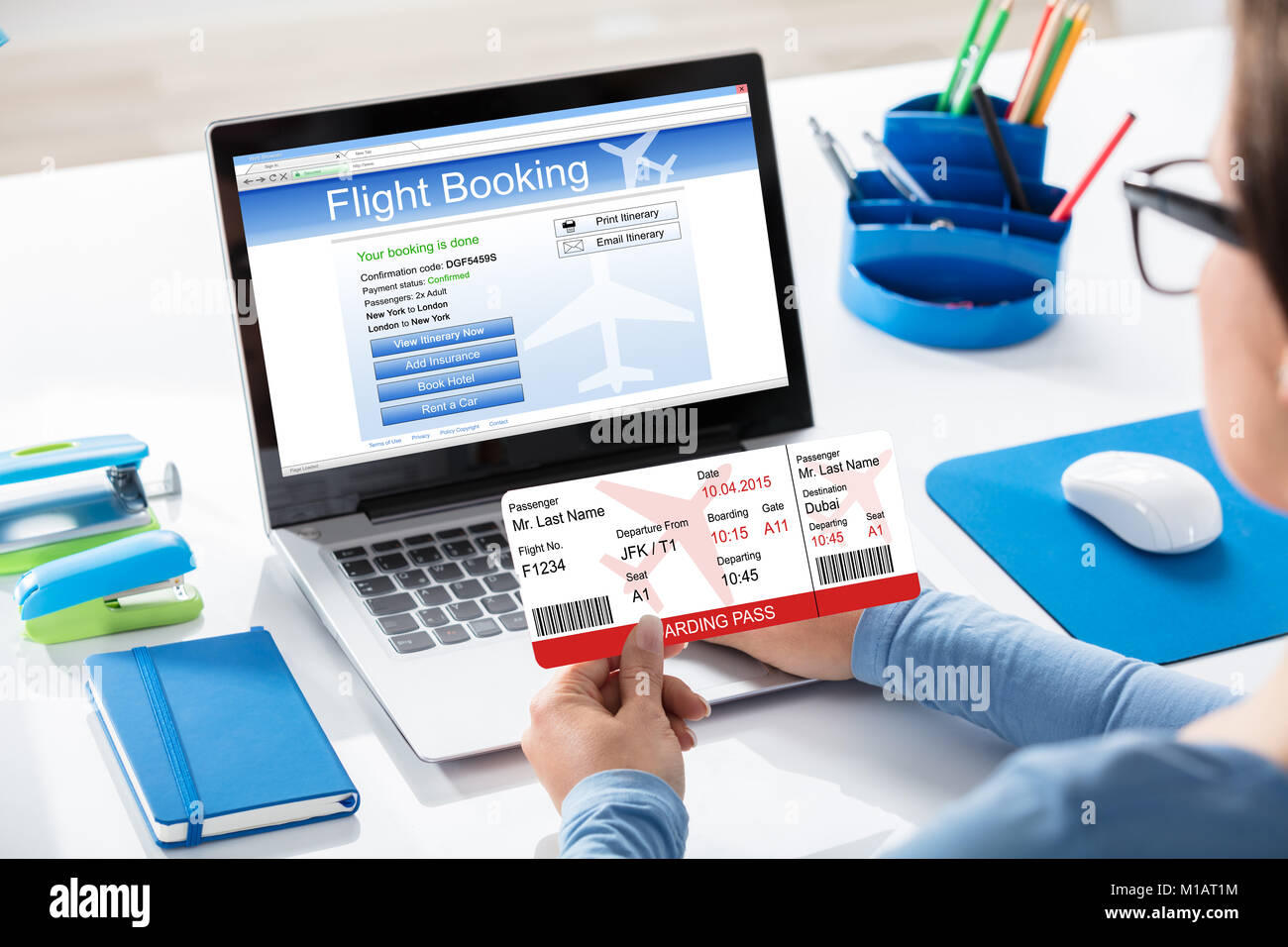 Close-up Of A Woman Holding Airline Ticket In Hand Booking Flight On Laptop Stock Photo