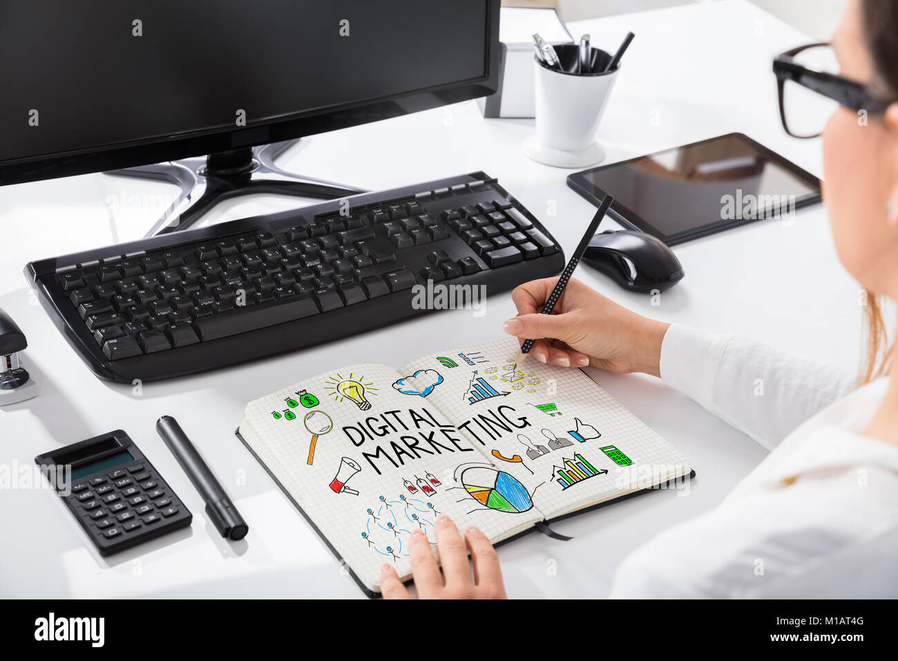Close-up Of A Businesswoman Drawing Digital Marketing Chart On Notebook In Office Stock Photo