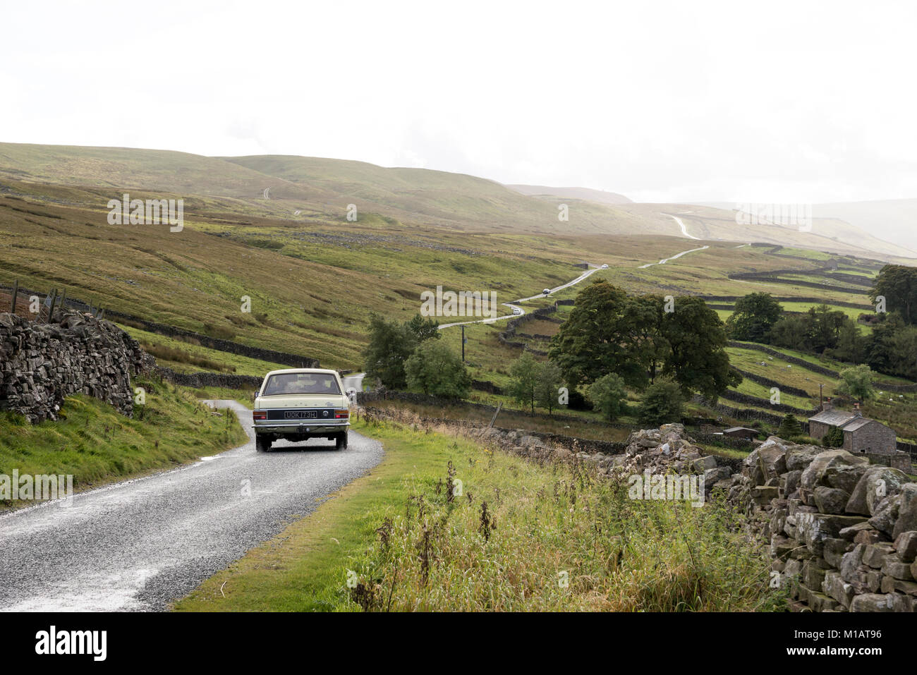 Old car on a remote road in Swaledale, Yorkshire Dales, England. Stock Photo