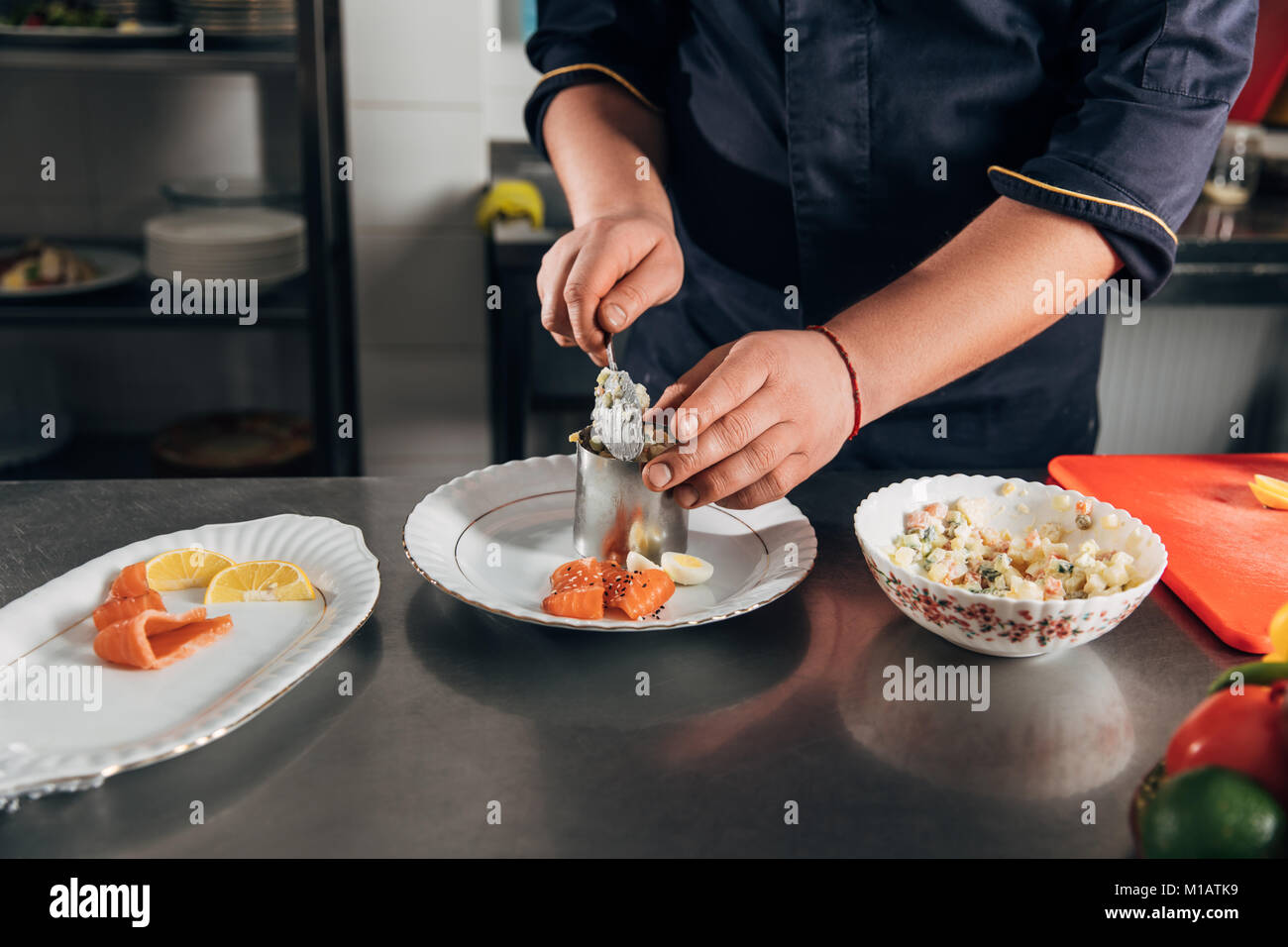 cropped shot of chef preparing salad with metal forming tube at restaurant Stock Photo
