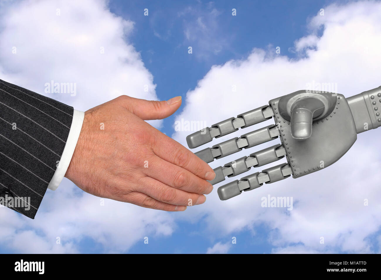 Handshake between a businessman and robotic hand, a meeting with technology concept. Stock Photo