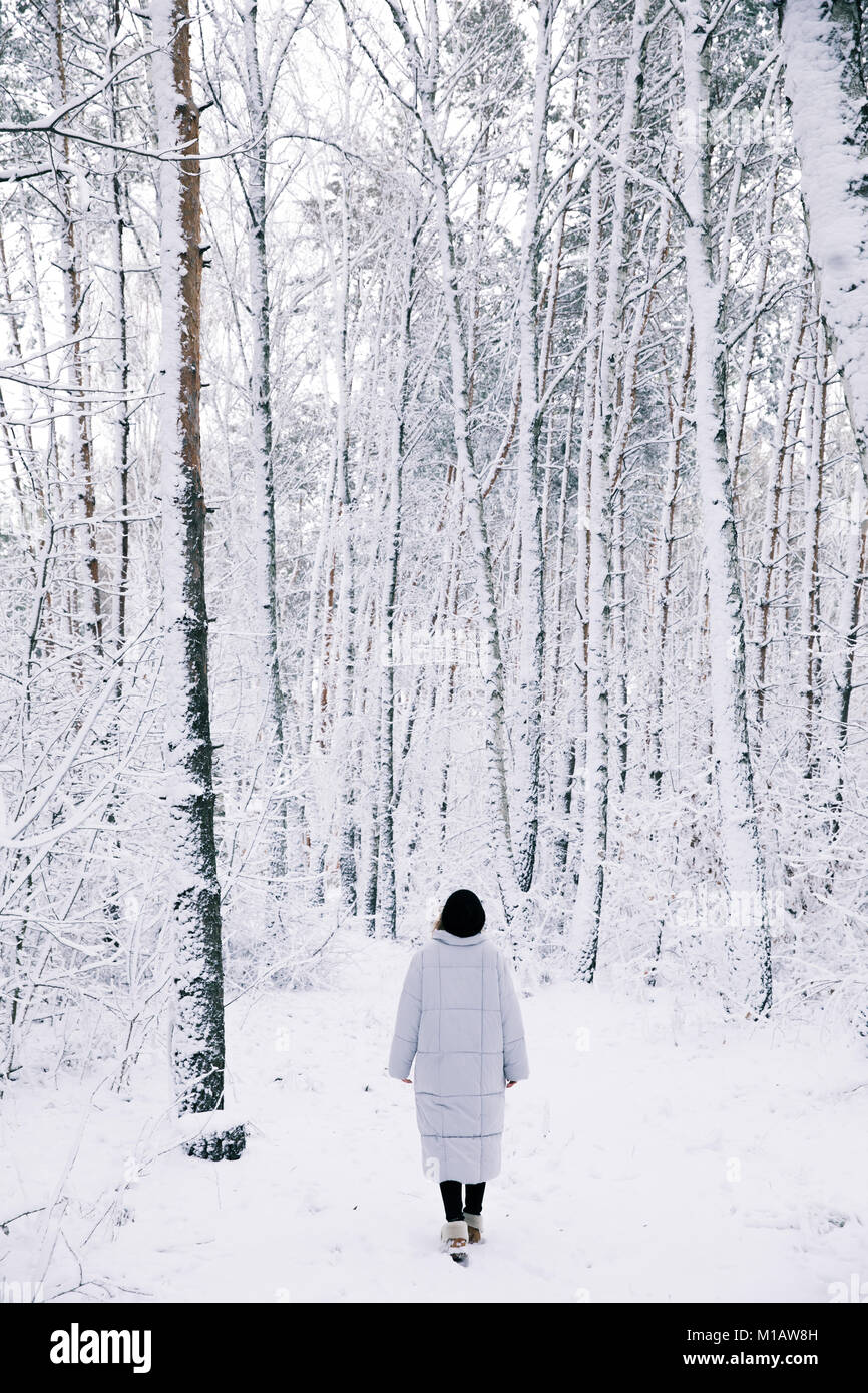 back view of woman walking in snowy forest Stock Photo - Alamy
