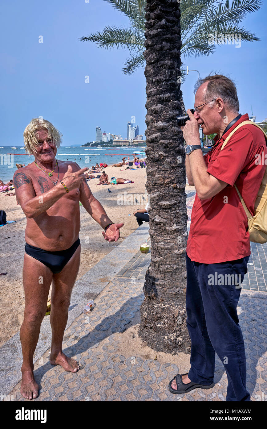 Photographer taking a photograph of a tanned mature shirtless man in speedo  swimming trunks Stock Photo - Alamy