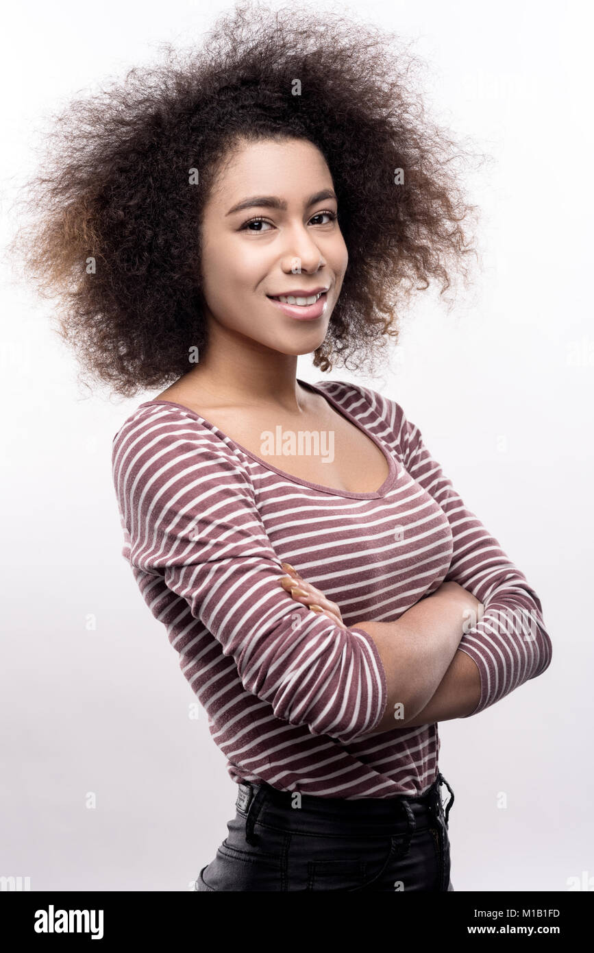 Curly-haired young folding her arms across chest Stock Photo