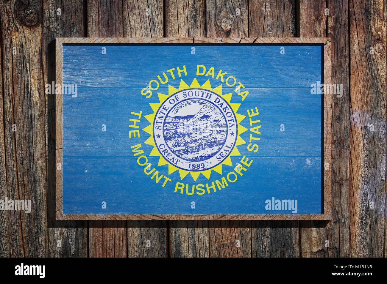 3d rendering of a South Dakota State USA flag on a wooden frame and a wood wall Stock Photo