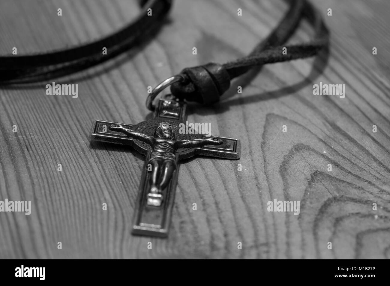 Crucifix cross necklace on a wood background in black and white Stock Photo