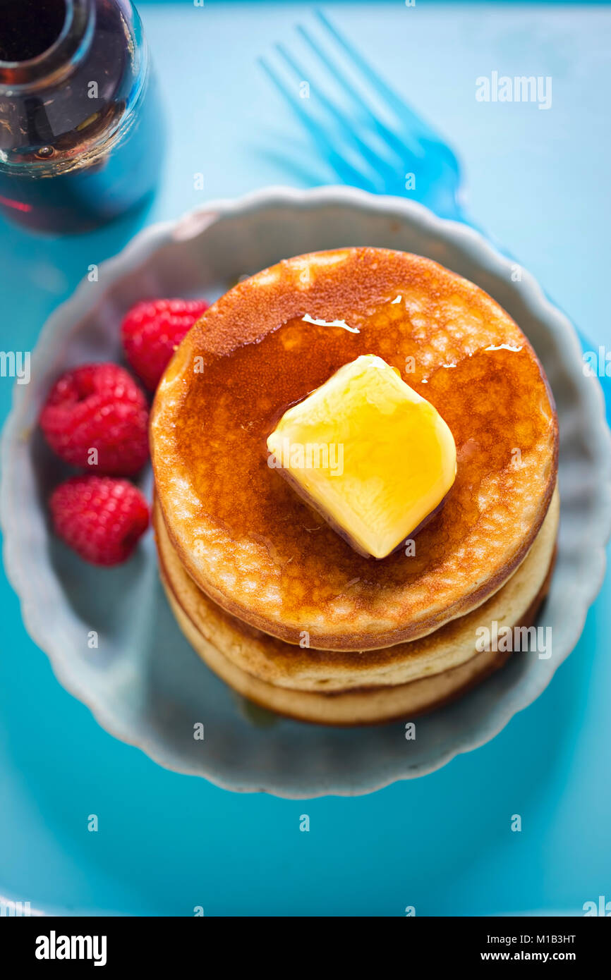 American pancakes with butter, maple syrup and raspberries Stock Photo