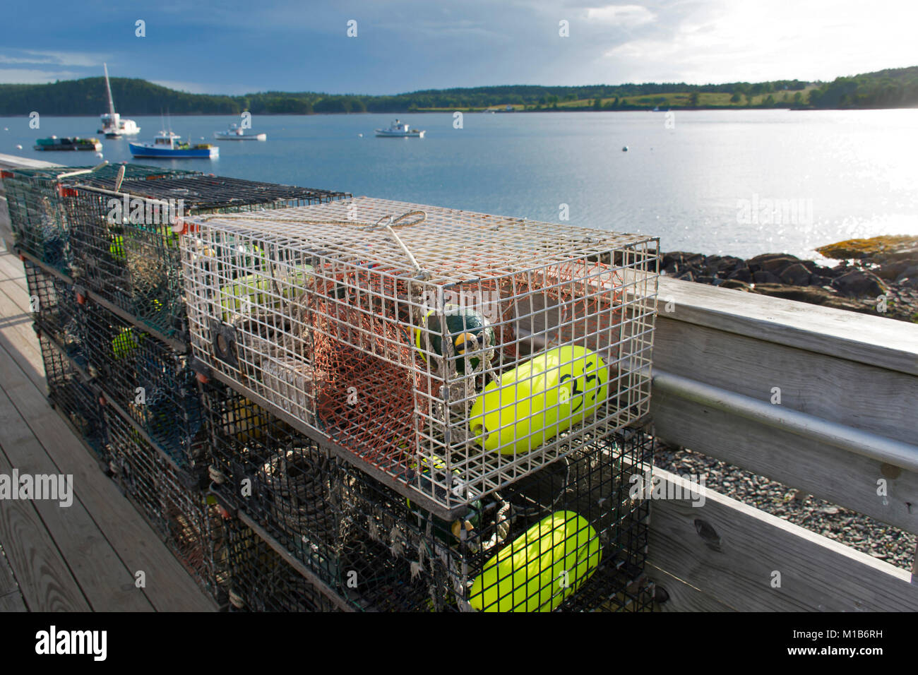 Lobster Traps on a dock with a harbor in the background - taken in Bartlett Narrows, Maine, USA Stock Photo