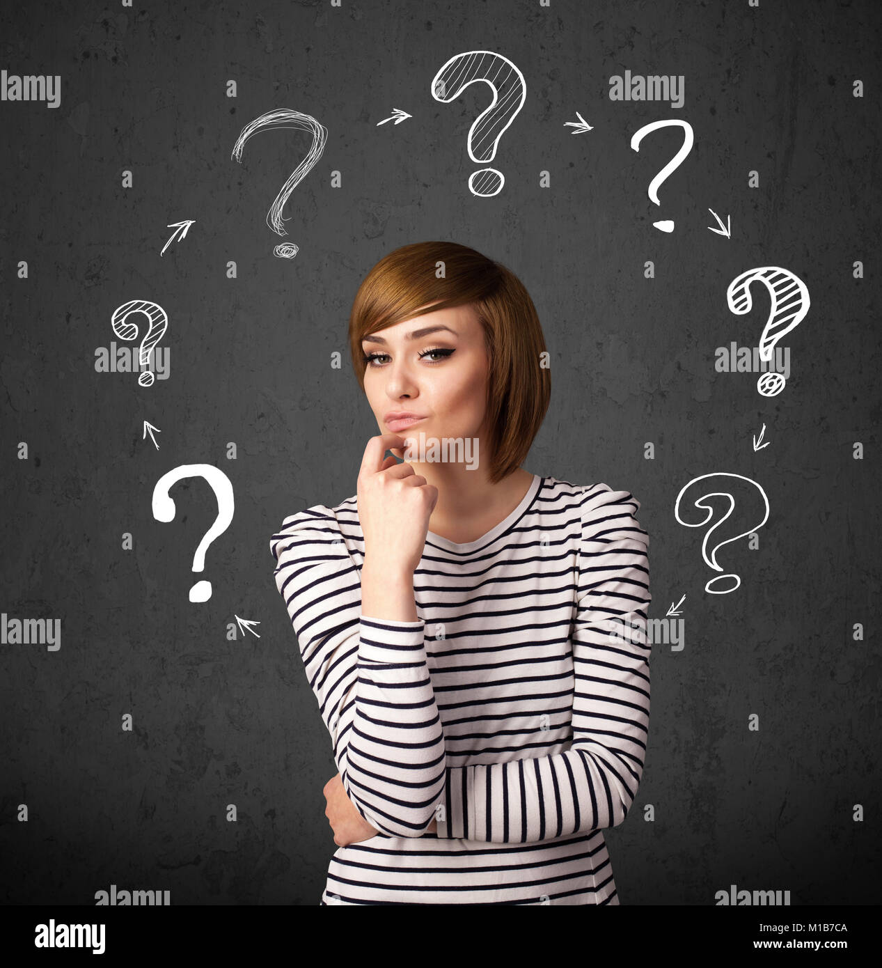 Thoughtful young woman with drawn question marks circulating around her ...