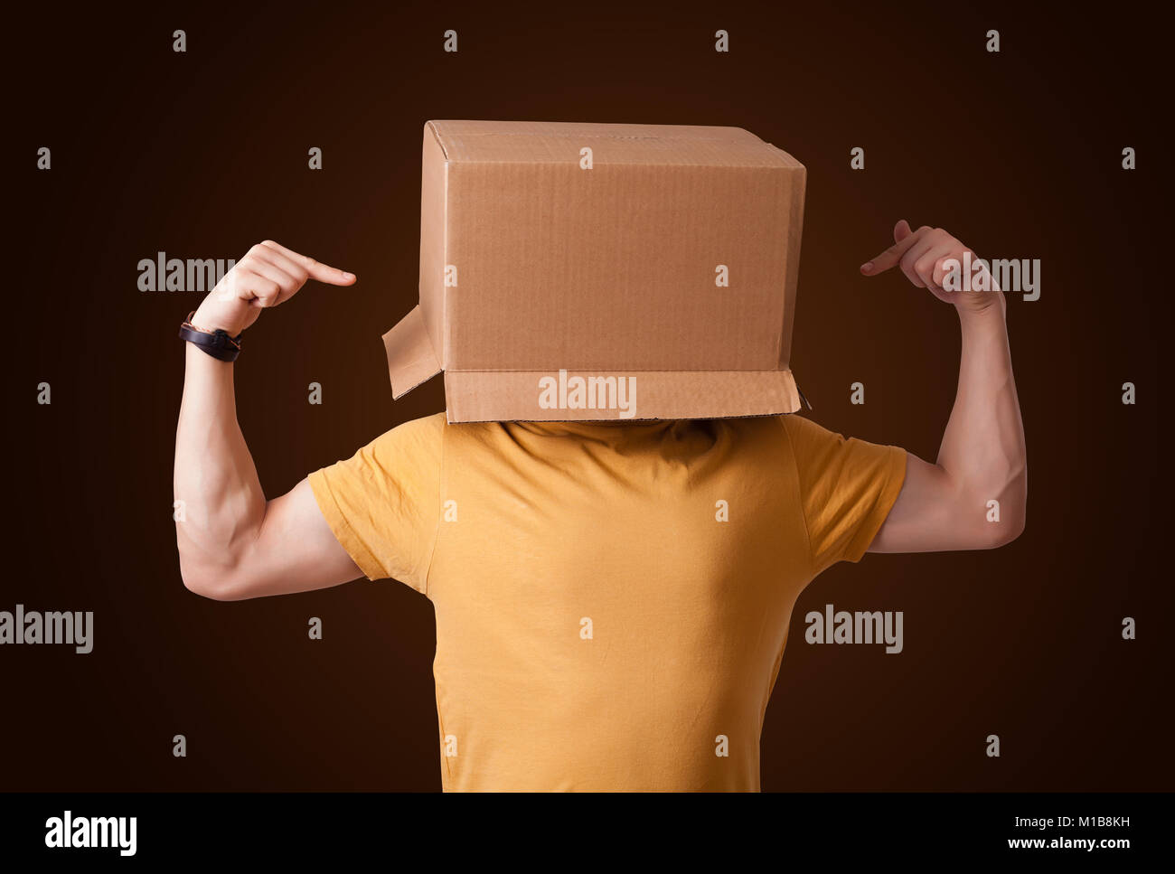 Young man standing and gesturing with a cardboard box on his head Stock ...