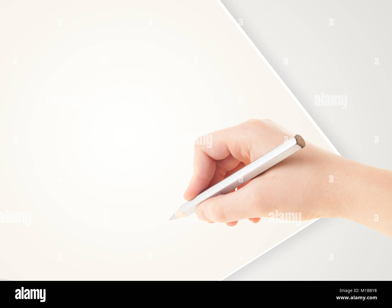 Human hand drawing with pencil on empty white paper template Stock