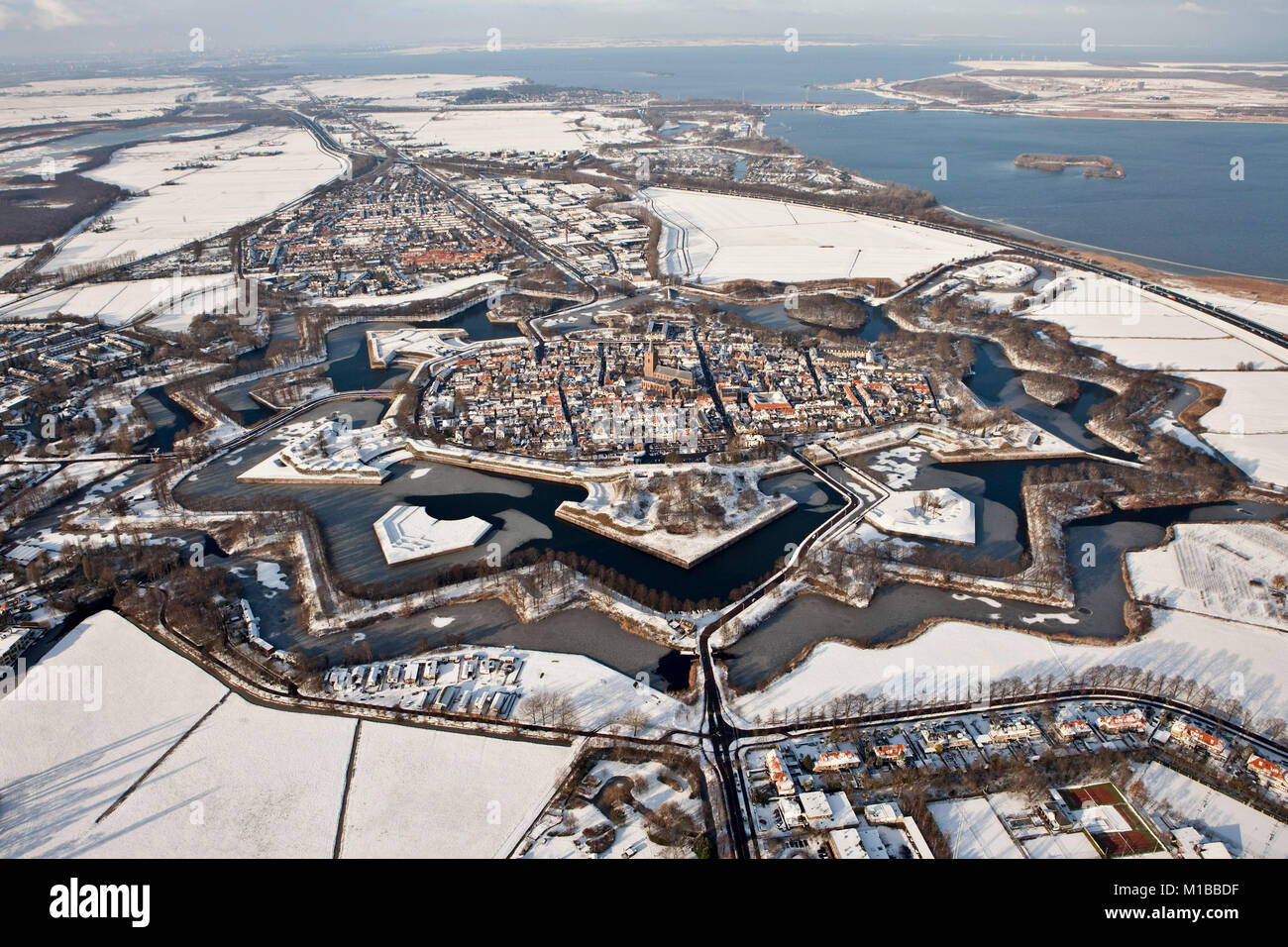 The Netherlands, Winter, Star shaped, fortified old city of Naarden snow covered. Aerial. Stock Photo