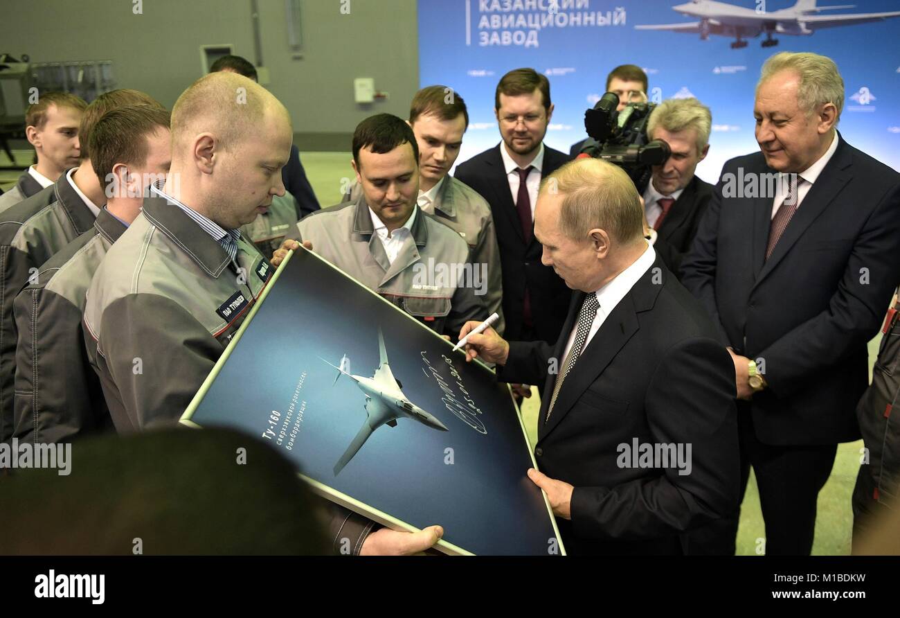 Russian President Vladimir Putin signs a photograph for workers during a tour of the Gorbunov Kazan Aviation Plant January 25, 2018 in Kazan, Tatarstan, Russia. Putin visited the factory and witnessed an agreement to purchase an upgraded version of the Tupolev Tu-160 Blackjack supersonic strategic bomber. Stock Photo