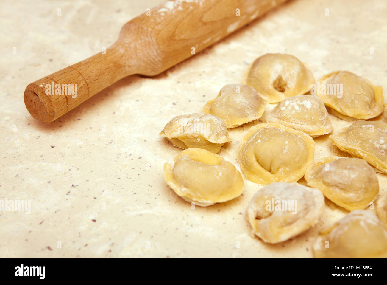cooking dumplings, rolling pin and ravioli on the table Stock Photo