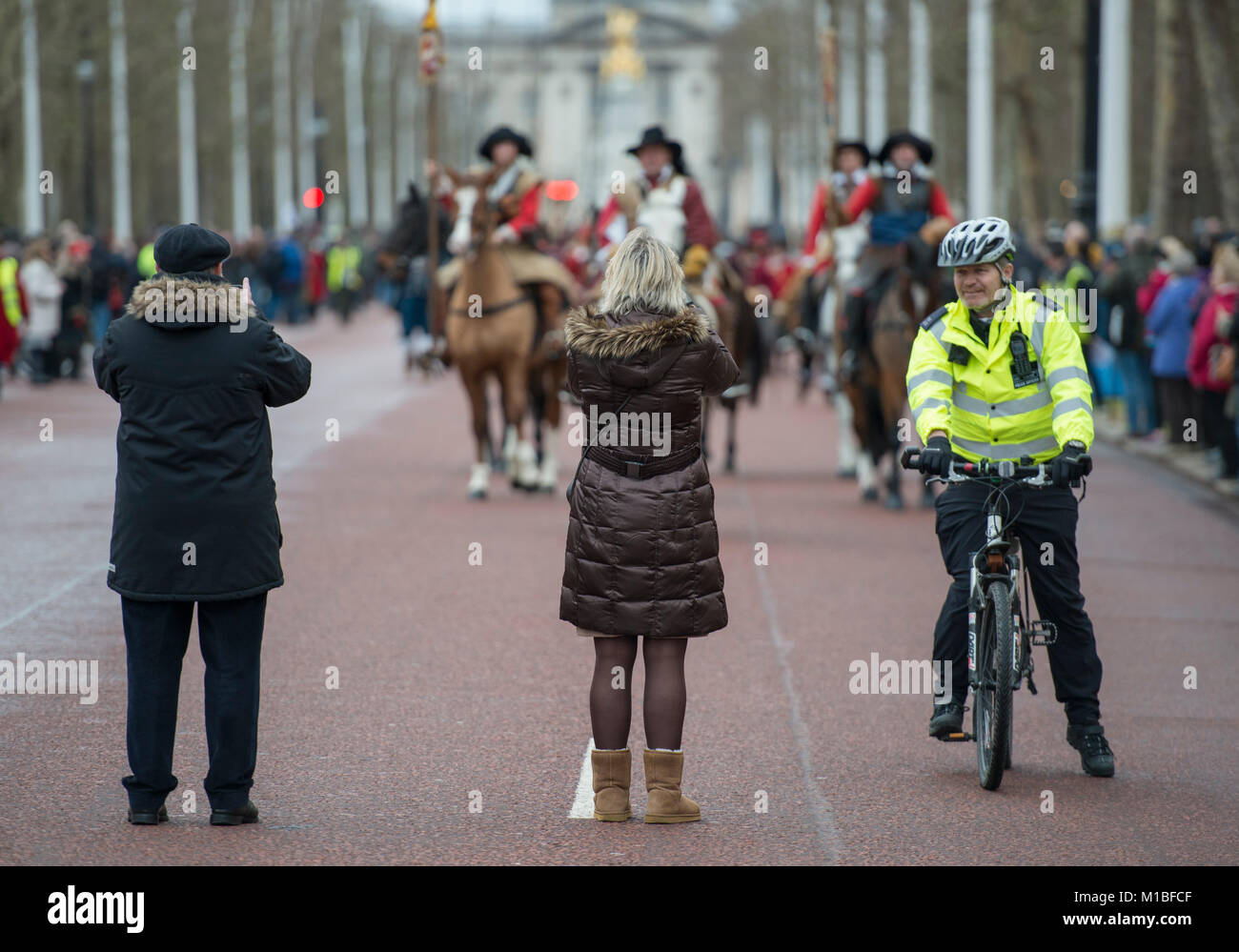 28 January 2018. The Kings March in London is photographed by tourists on The Mall, watched by policeman. Credit: Malcolm Park/Alamy. Stock Photo
