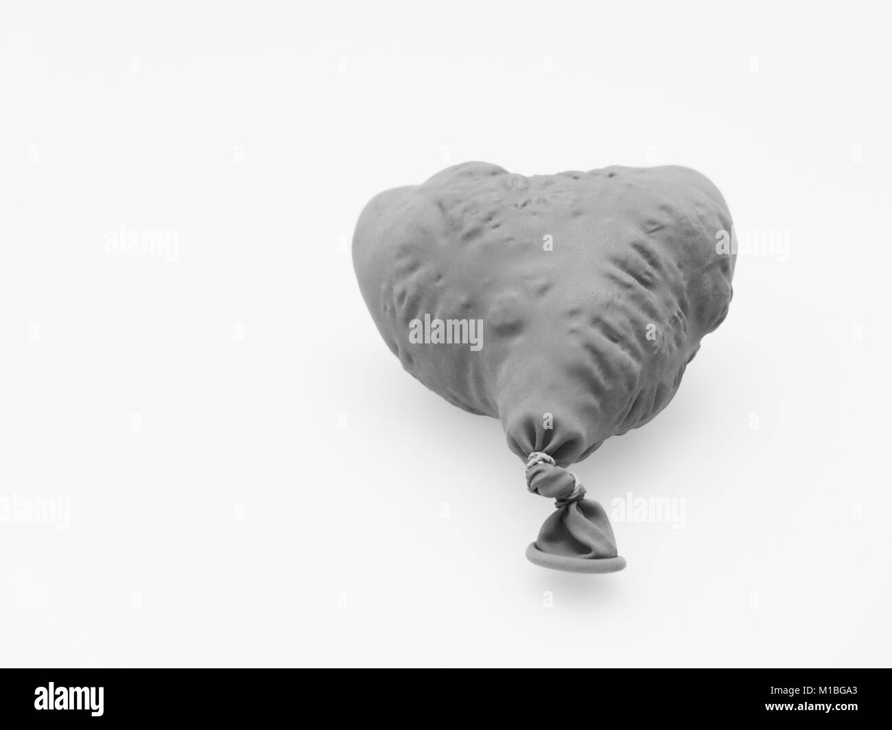 Deflate heart shape balloon in black and white isolated on white background Stock Photo