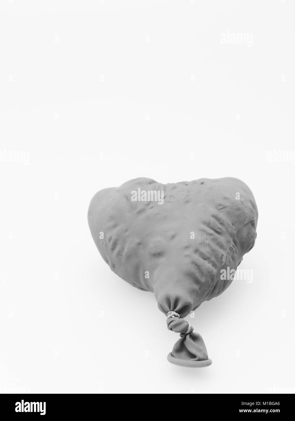 Deflate heart shape balloon in black and white isolated on white background Stock Photo