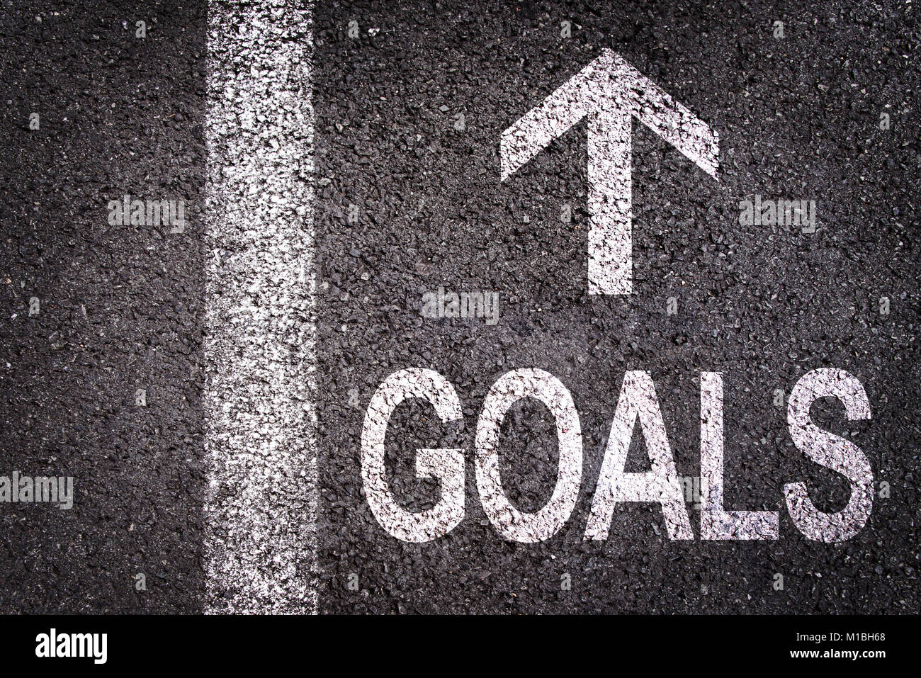 Word Goals and an arrow written on an asphalt road background Stock Photo
