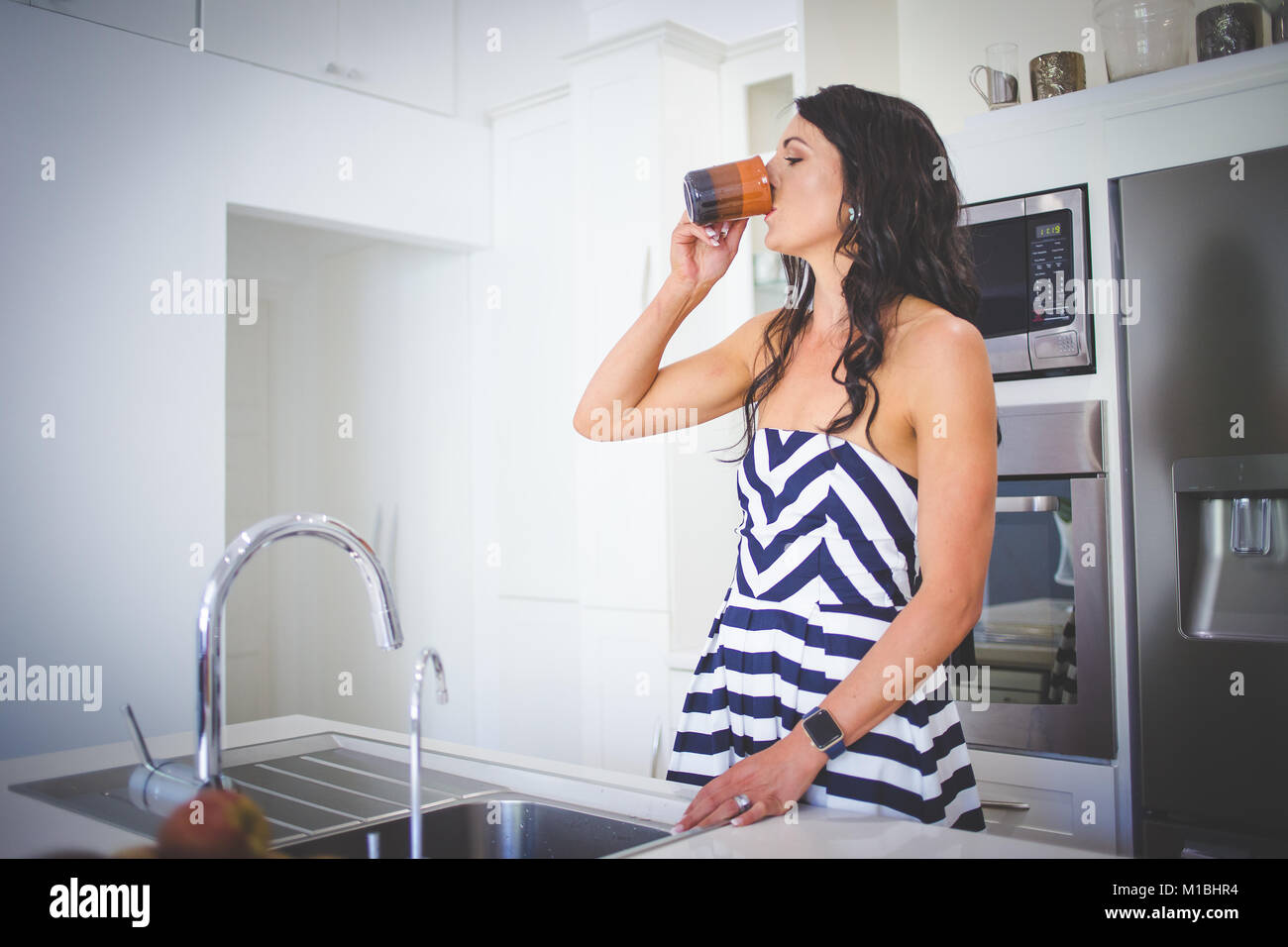 Beautiful brunette female model working in her stylish kitchen Stock ...