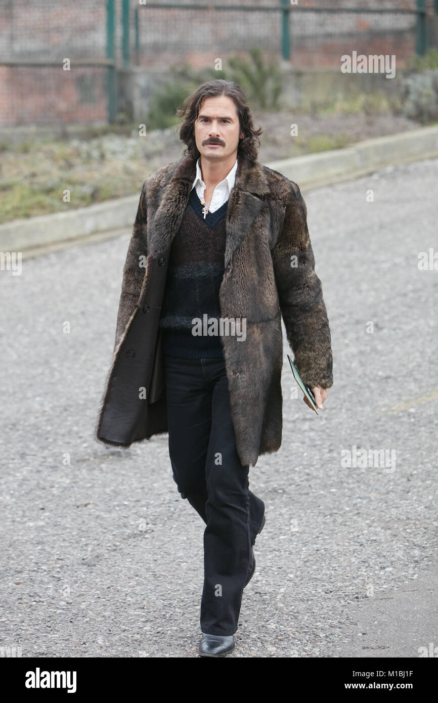 MILAN - JANUARY 15: Man with brown fur coat before Pal Zileri fashion show, Milan Fashion Week street style on January 15, 2018 in Milan. Stock Photo