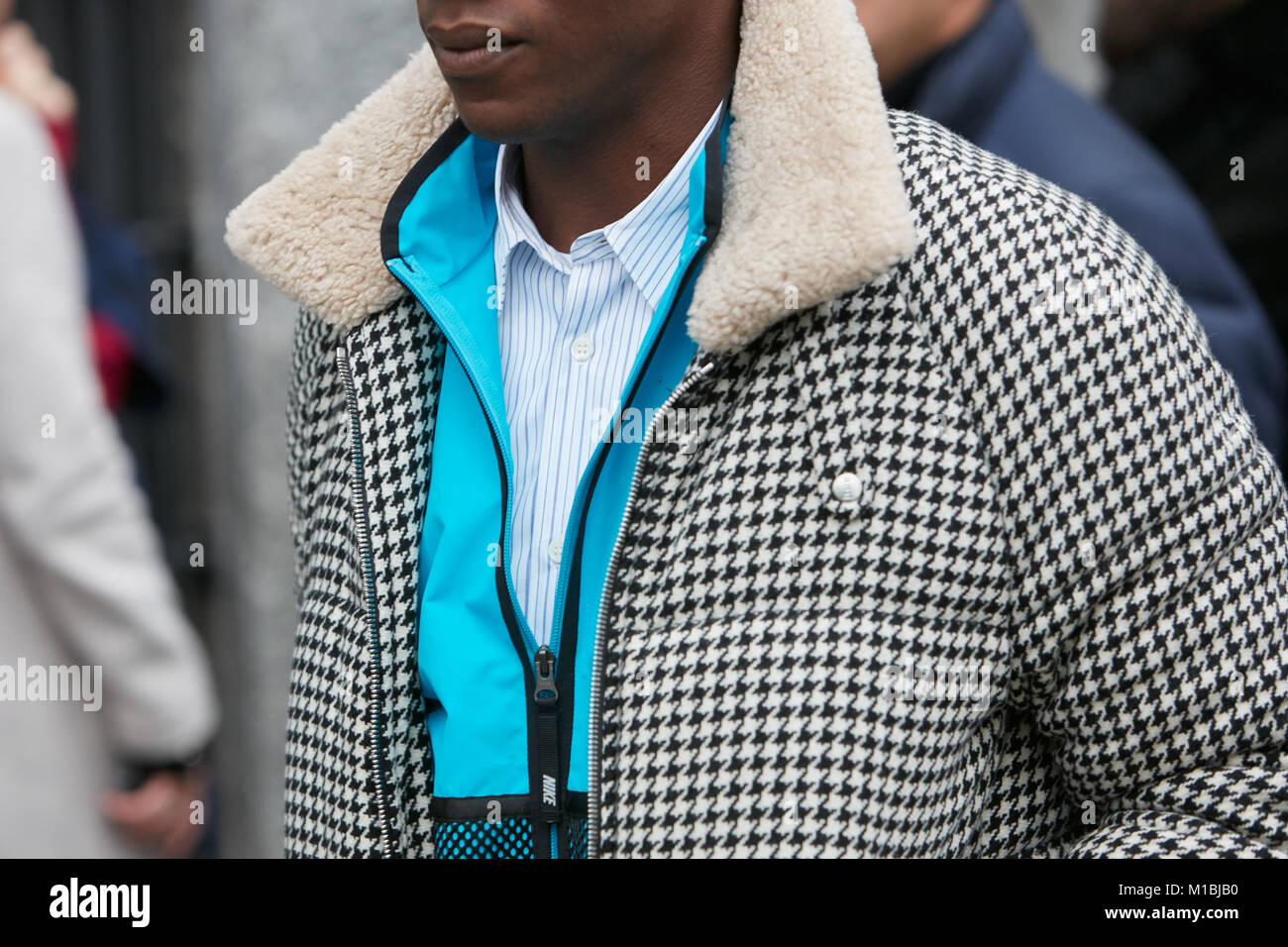 MILAN - JANUARY 15: Man with black and white houndstooth jacket and blue Nike sweatshirt before Giorgio Armani fashion show, Milan Fashion Week street Stock Photo