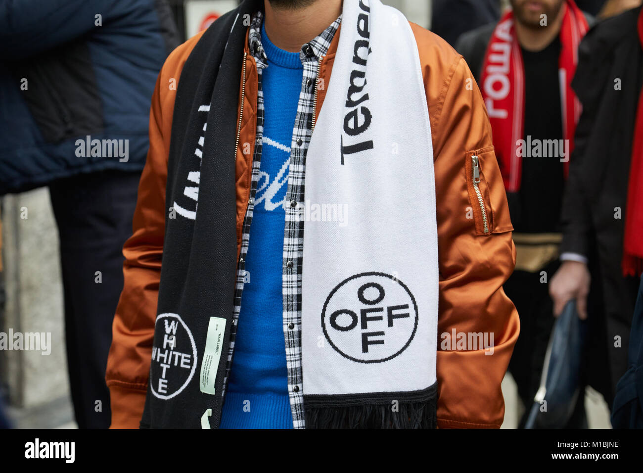 MILAN - JANUARY 15: Man with black and white Off White scarf and bronze satin bomber jacket before Giorgio Armani fashion show, Milan Fashion Week str Stock Photo