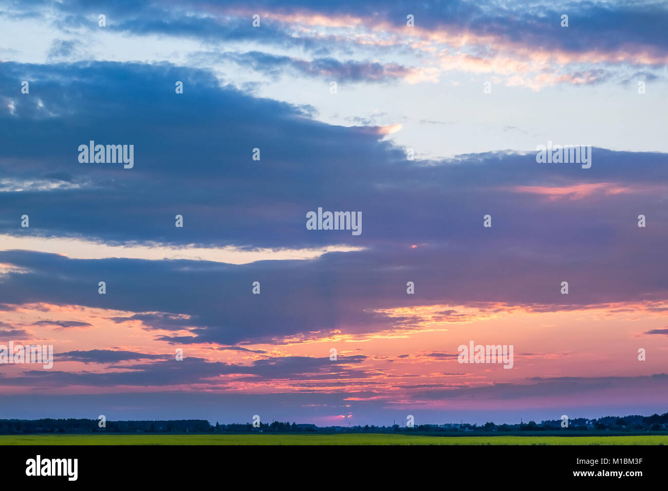 Sunset sky with clouds over green field Stock Photo - Alamy