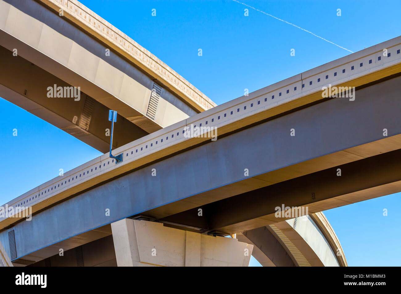 Section of elevated highway with several levels against a bright blue sky Stock Photo