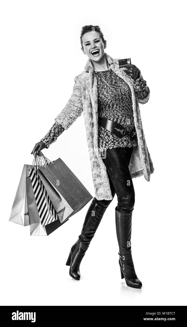 Winter things. Full length portrait of happy modern fashion-monger in winter coat isolated on white background with shopping bags showing credit card Stock Photo