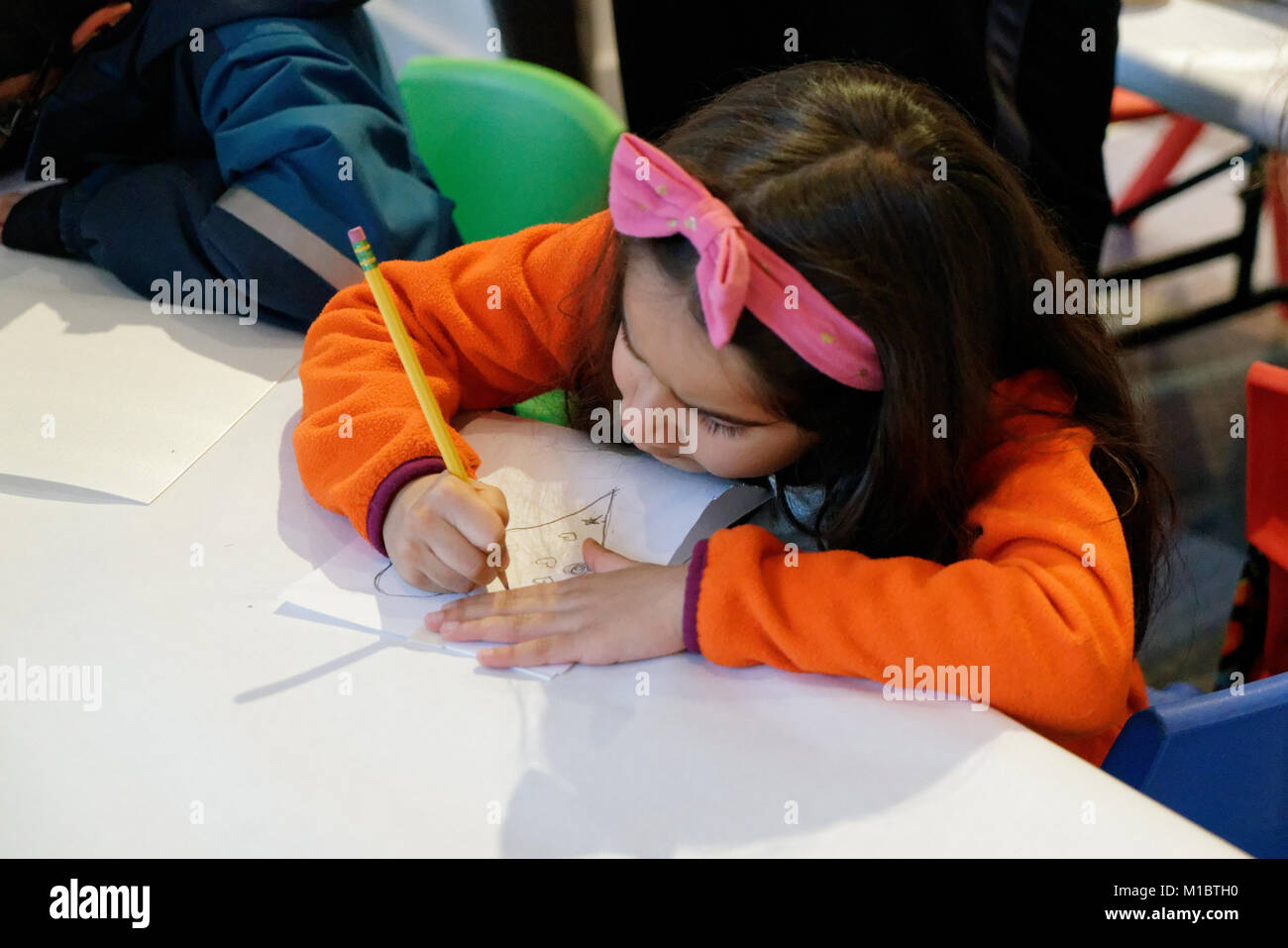 A girl drawing hearts with a pencil. Stock Photo