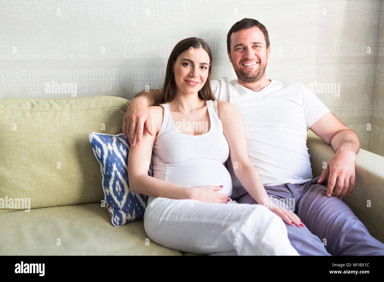 Pregnant woman and young man together indoors Stock Photo - Alamy