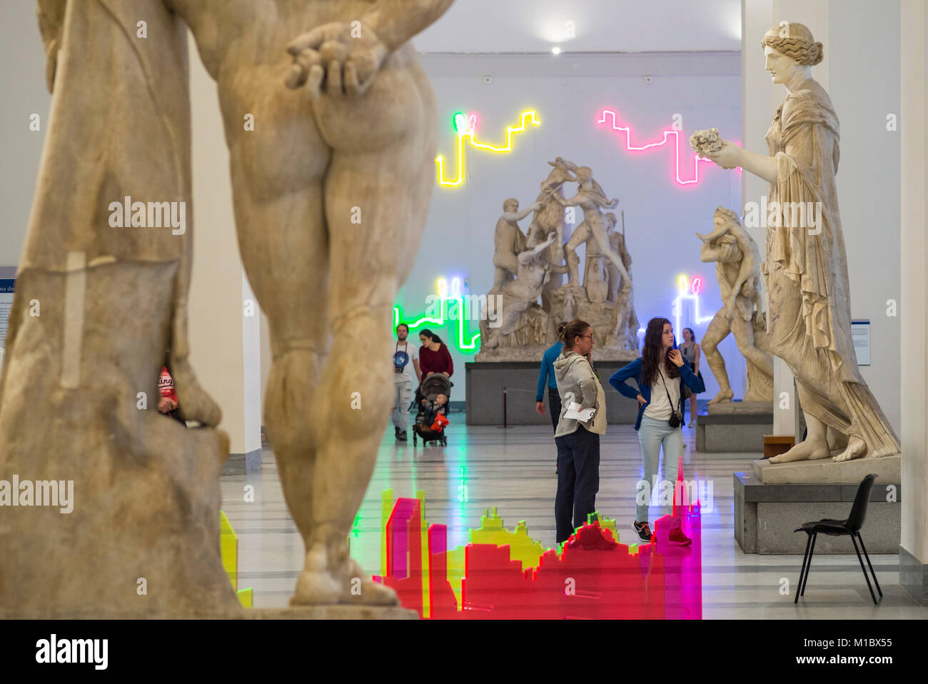 Naples. Italy. Visitors to Naples National Archaeological Museum looking at the Farnese sculpture collection, with site specific installation, “Proiez Stock Photo