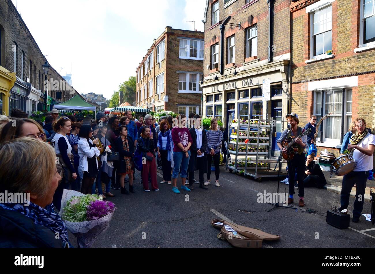 a band of musicians playing in columbia road flower market east london UK on a sunny sunday 2017 Stock Photo