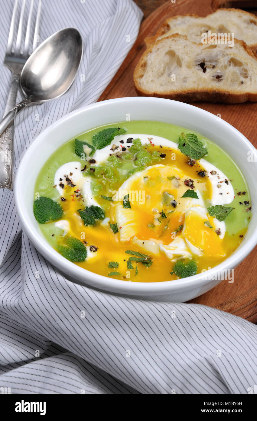 Pea puree soup with poached egg, sour cream, mint leaves seasoned with spices Stock Photo Alamy